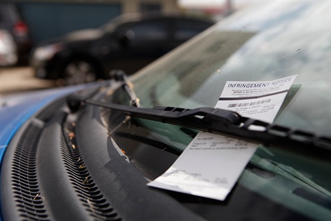 A photo of a police ticket sitting in a windscreen wiper